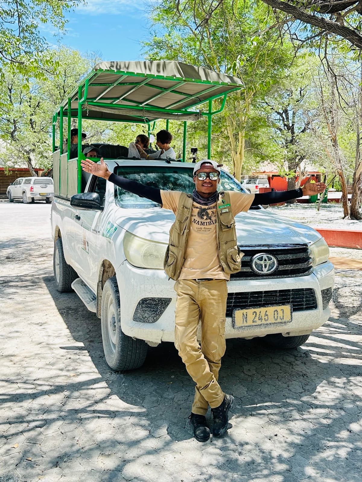 Abi, Yavola Tours guide standing by a safari vehicle